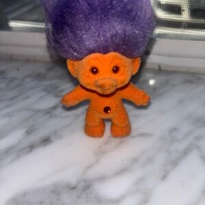 Vibrant Orange Troll Figure with Purple Hair